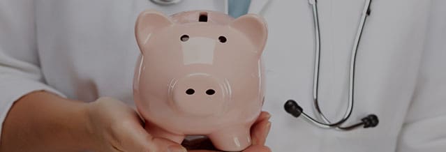 Doctor with Stethoscope Holding Piggy Bank 